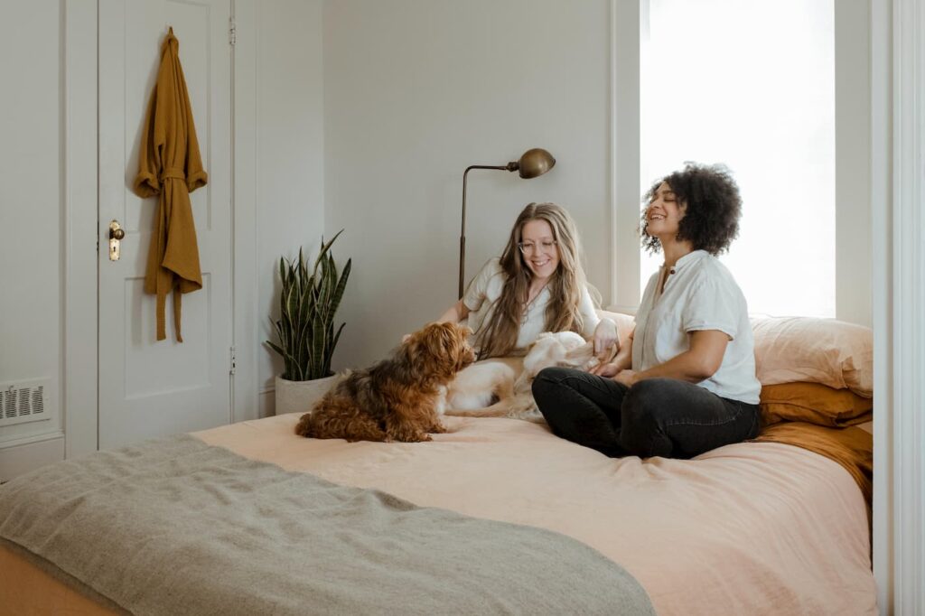 Happy long-term tenants sitting on their bed with their dog