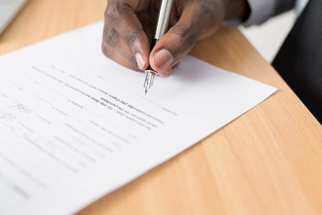 A man signing a lease agreement using a fountain pen