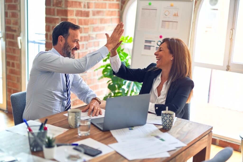 Two professionals exchanging a high-five after sharing useful property management tips