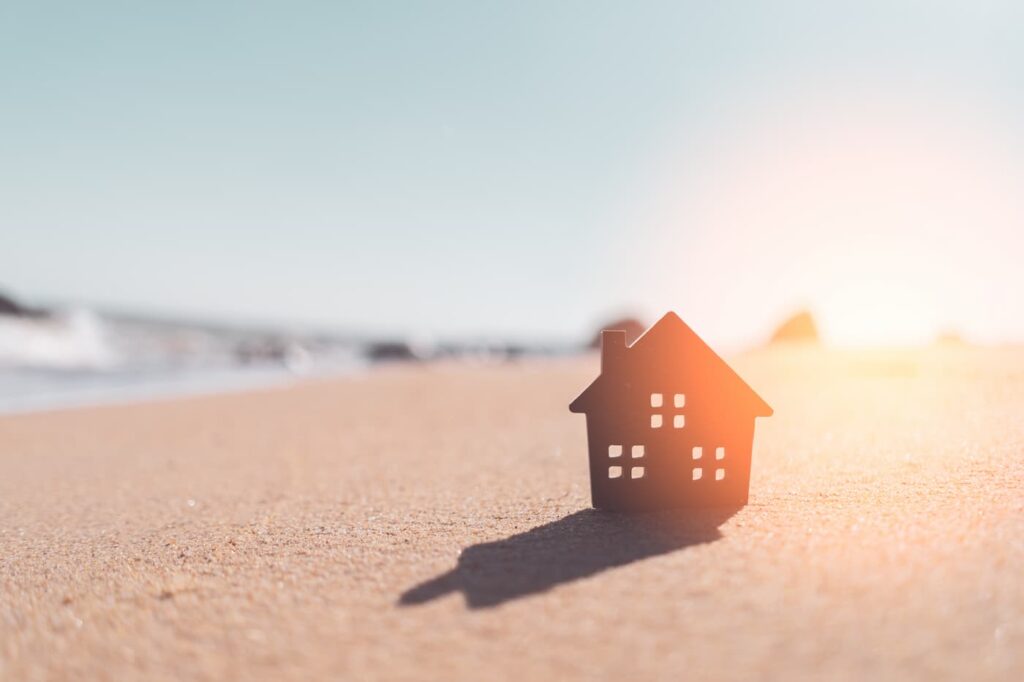 A model of a house on a sandy beach illustrating a short-term rental