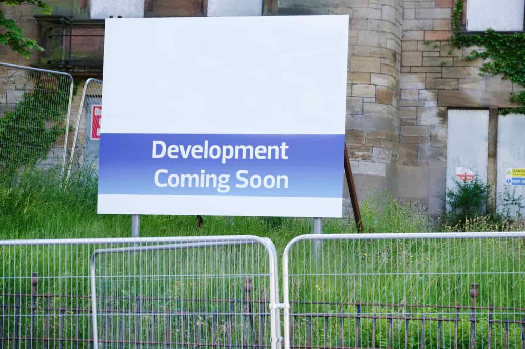 a sign that says development coming soon to alleviate the housing shortage