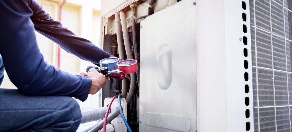 A man performs pressure testing on an outdoor HVAC unit