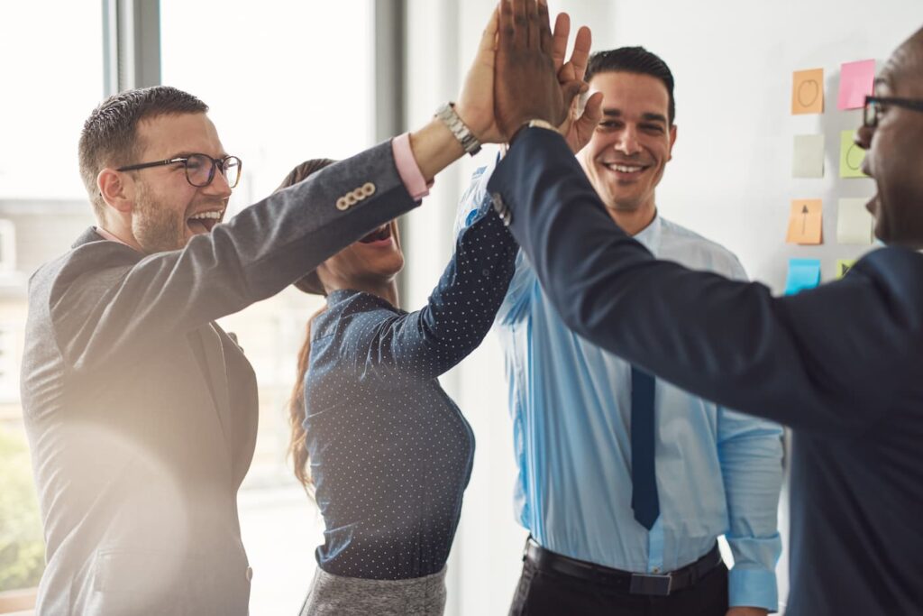 a property management team sharing a group high-five.