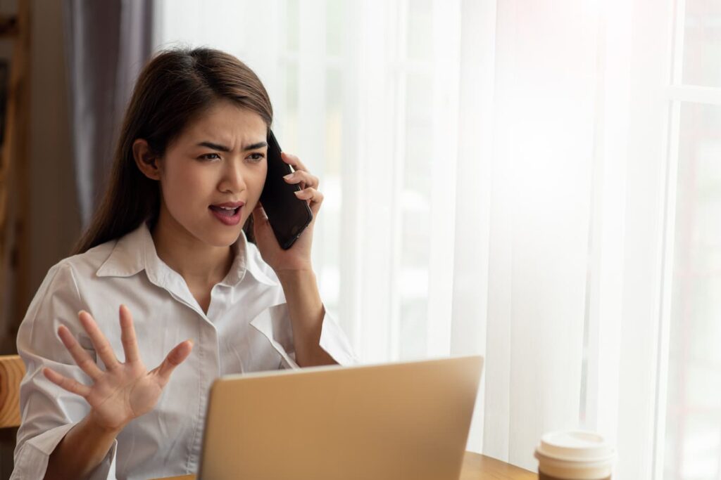 A woman on a stressful phone call with a bad property manager.