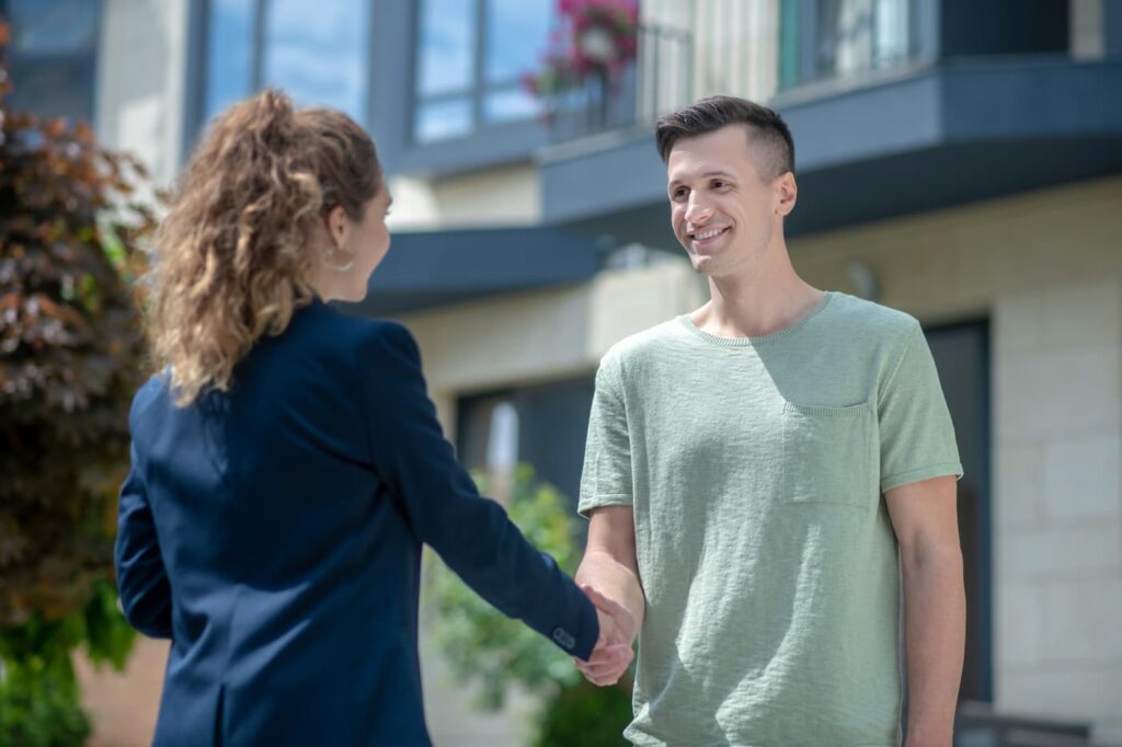 A property manager shakes hands with a new renter after following tips on how to find and keep great tenants.