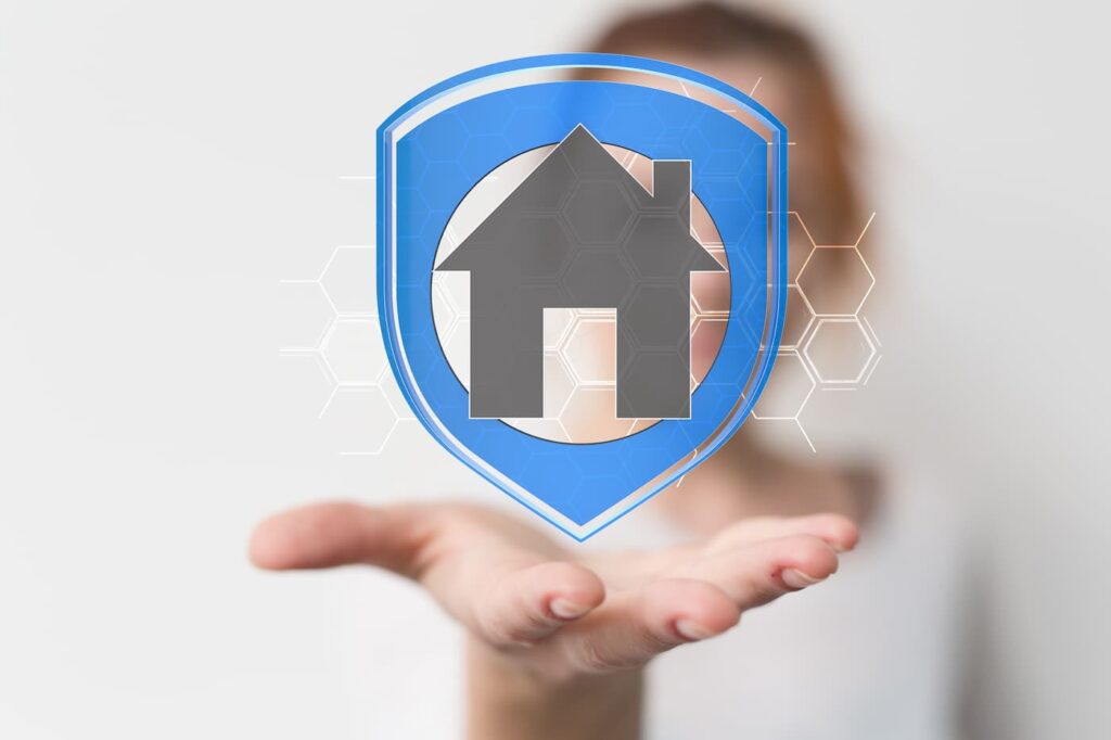 A person holds up a house surrounded by a shield to represent how to keep your home secure.