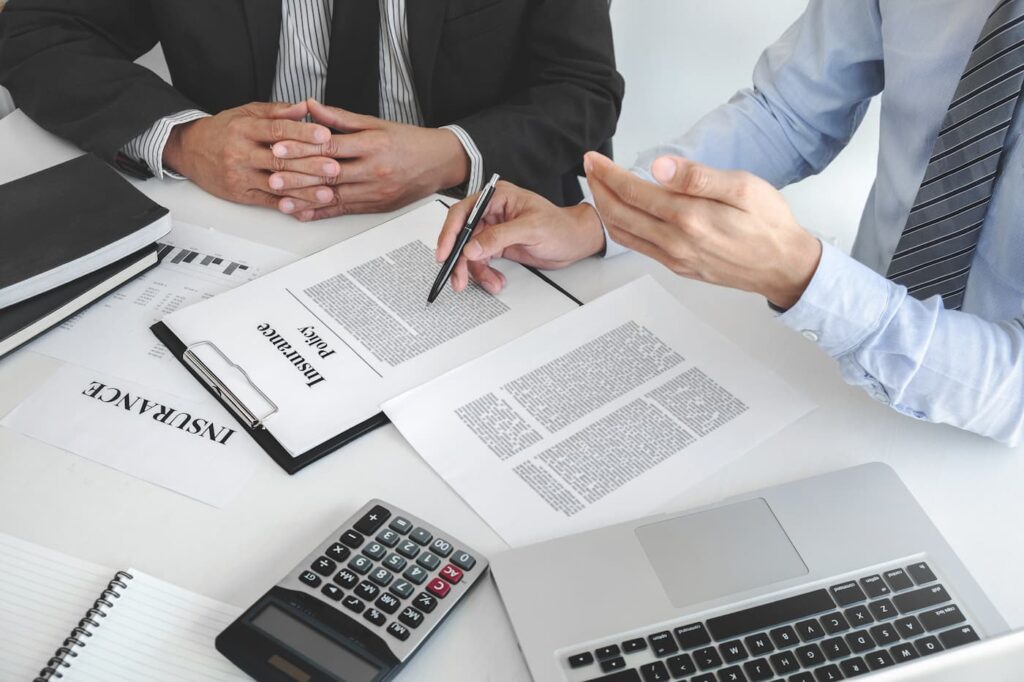 An agent talks over the benefits of renter's insurance with interested parties at a table.