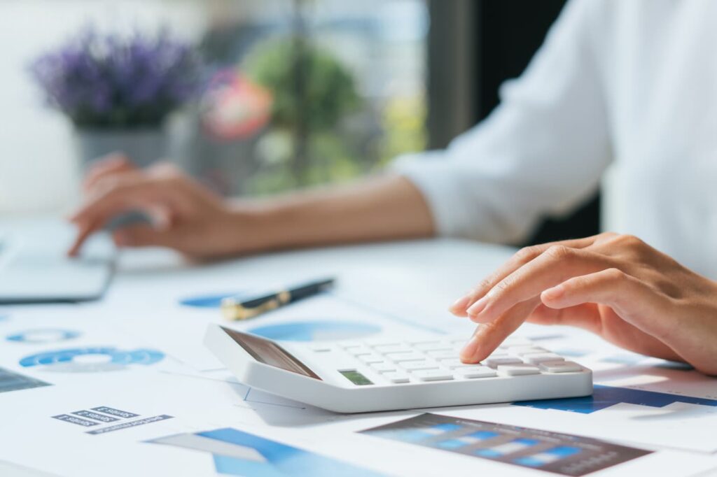 A person works on budgeting for property management at a desk.